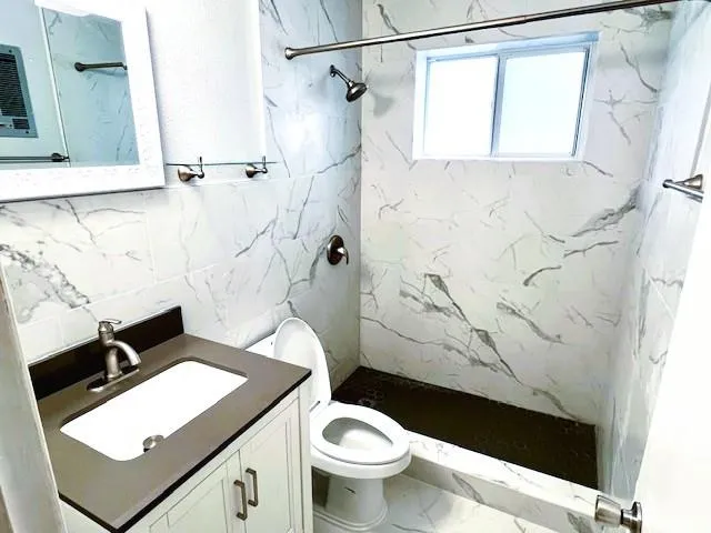 a bathroom with a granite countertop sink toilet and shower