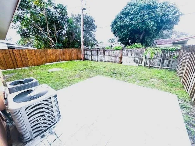 a view of a backyard with a garden and wooden fence