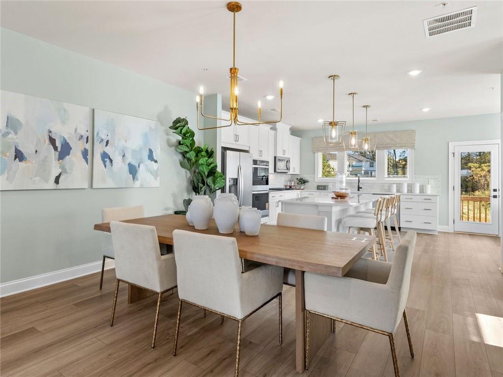 6410 Pinin Place Cumming, GA 30041 - Photo 7 of 11 a view of a dining room with furniture wooden floor and a chandelier
