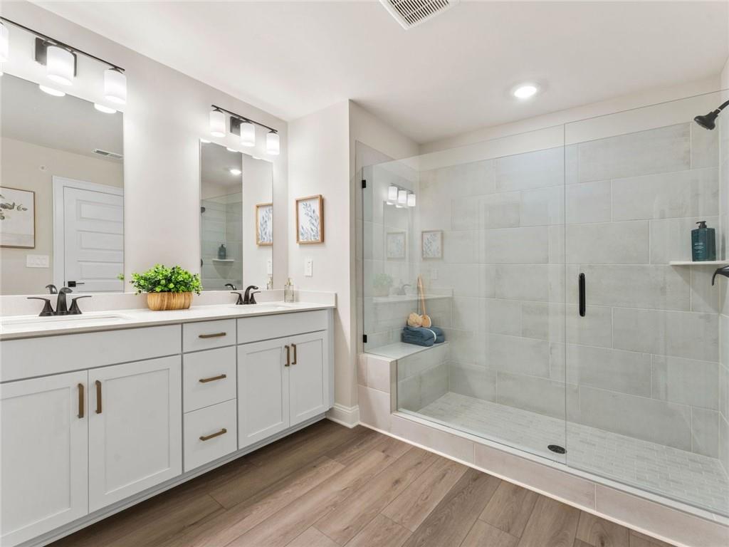 6410 Pinin Place Cumming, GA 30041 - Photo 9 of 11 a bath room with a sink shower and a mirror