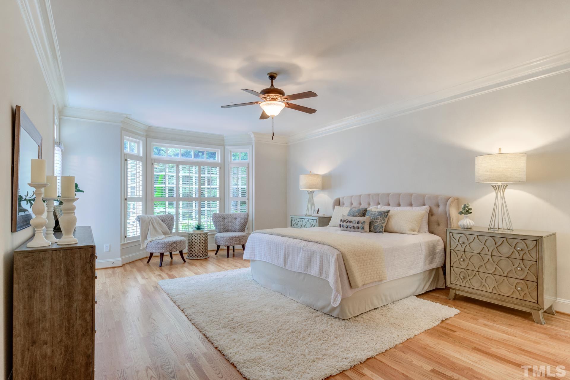 109 Ronsard Lane Cary, NC 27511 - Photo 14 of 26 a bedroom with a large bed a chandelier and windows