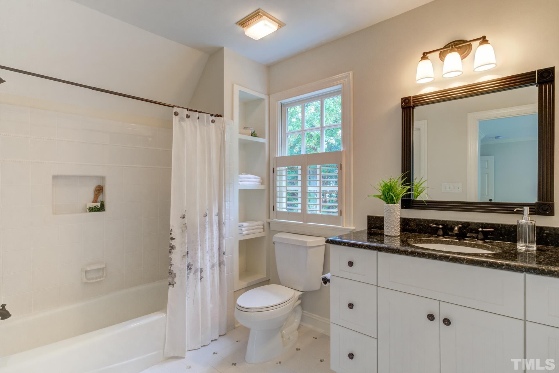 109 Ronsard Lane Cary, NC 27511 - Photo 21 of 26 a bathroom with a granite countertop sink toilet a large mirror a shower and a bathtub