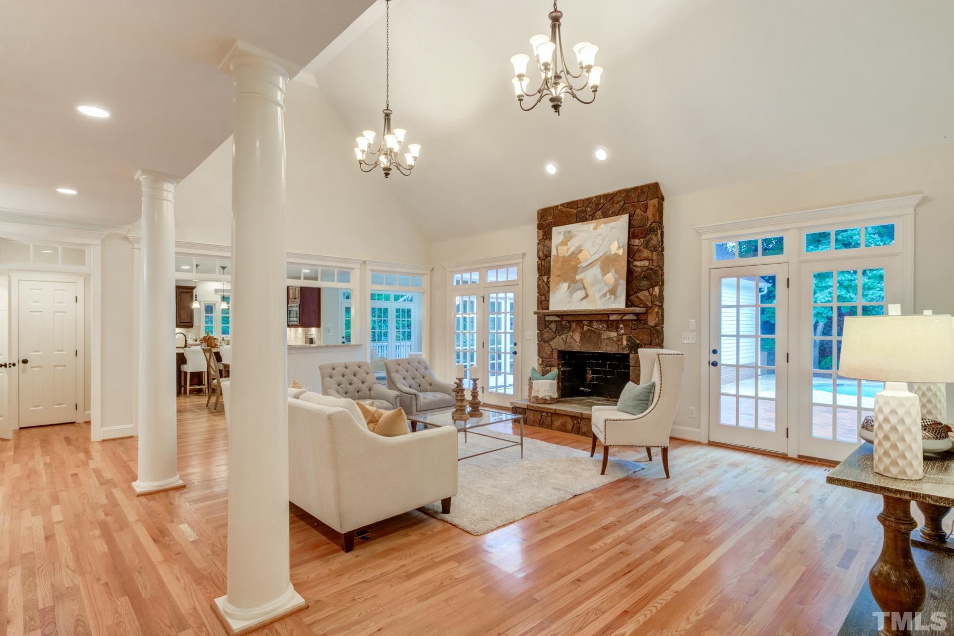 109 Ronsard Lane Cary, NC 27511 - Photo 7 of 26 a living room with furniture a fireplace and a chandelier