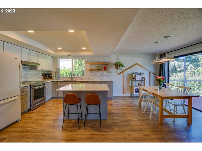 111 Northeast 19th Avenue Camas, WA 98607 - Photo 11 of 48 a kitchen with stainless steel appliances granite countertop a refrigerator a oven a sink with a dining table and chairs