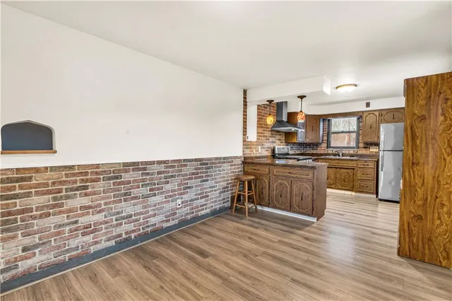 a kitchen with stainless steel appliances a refrigerator and a stove top oven