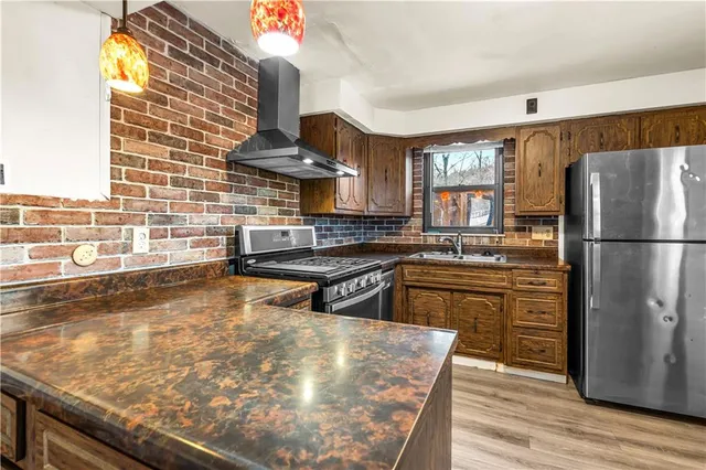 a kitchen with stainless steel appliances granite countertop a sink stove and refrigerator