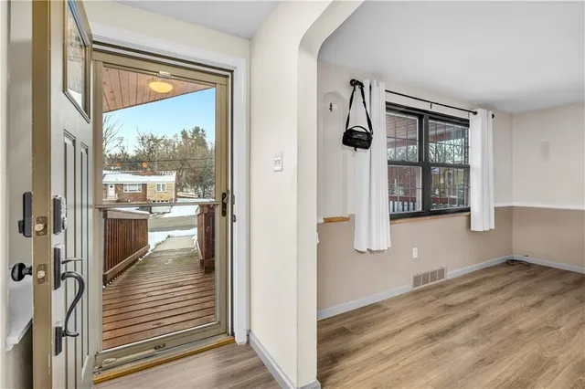 a view of a hallway with wooden floor and a living room