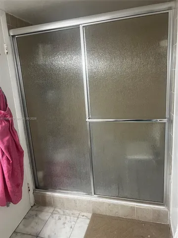 a bathroom with a glass shower door
