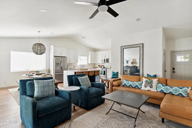 a living room with furniture kitchen view and a window