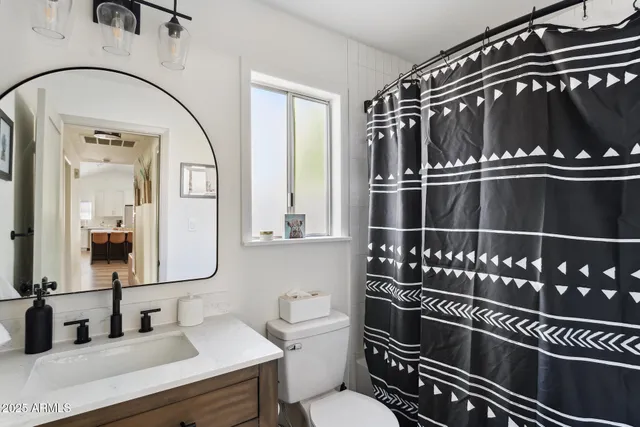 a bathroom with a toilet a sink and mirror
