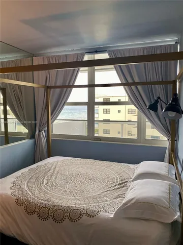 a large bed sitting in a bedroom next to a window