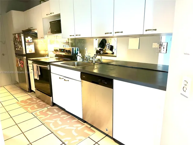 a kitchen with stainless steel appliances granite countertop a sink refrigerator and microwave