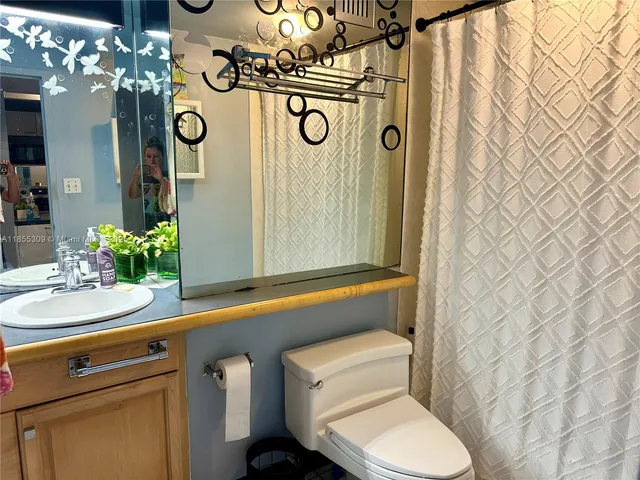 a bathroom with a toilet a sink and a mirror