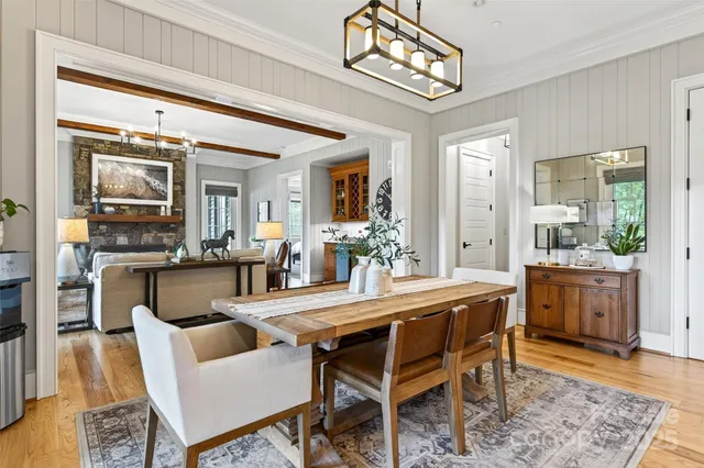 a dining room with furniture a kitchen view and a chandelier