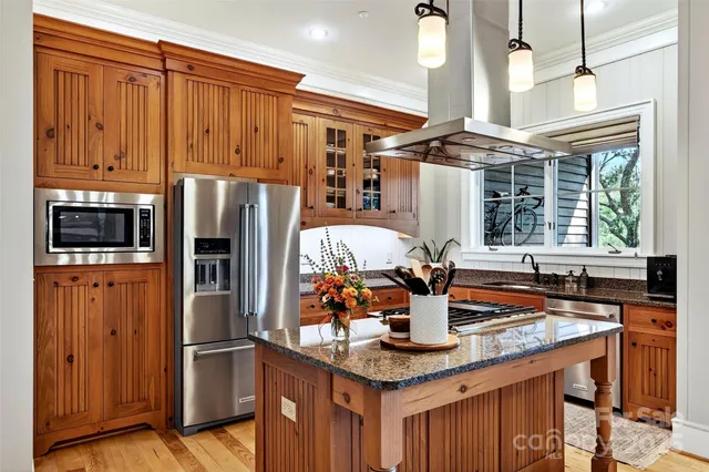 a kitchen with stainless steel appliances granite countertop a refrigerator a stove and a sink