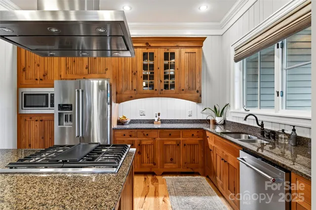 a kitchen with stainless steel appliances a stove a sink and a refrigerator