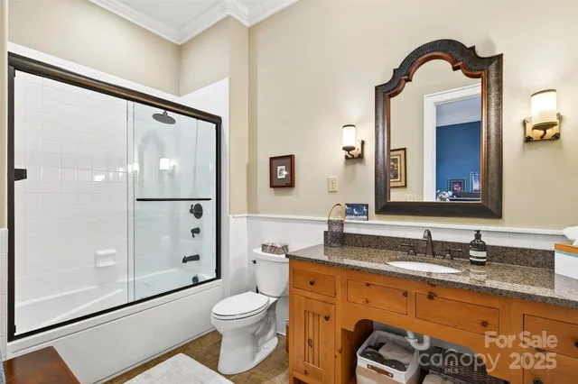 a bathroom with a granite countertop sink mirror vanity and toilet