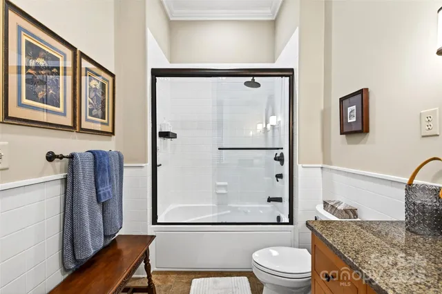 a bathroom with a granite countertop sink toilet a mirror and shower