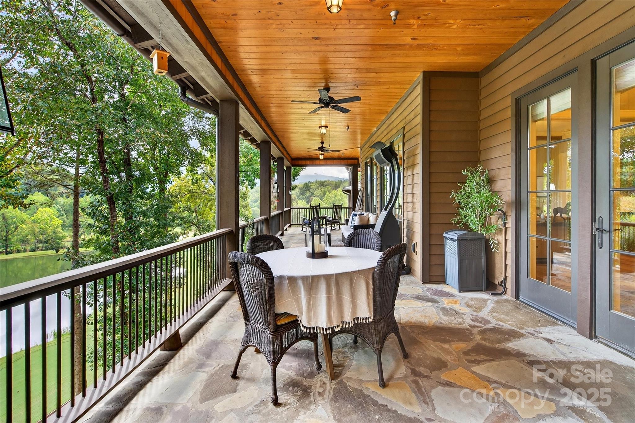 275 Clubhouse, Unit C202 Mill Spring, NC 28756 - Photo 32 of 48 a view of a patio with table and chairs and floor to ceiling window with wooden floor