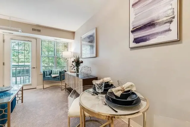 a dining room with furniture and a window