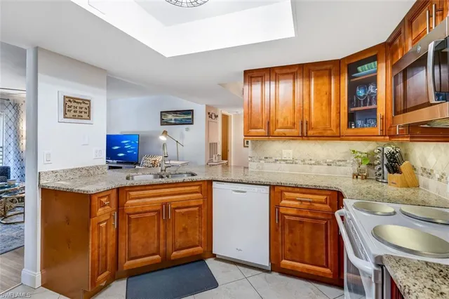 a kitchen with stainless steel appliances granite countertop a sink stove and cabinets