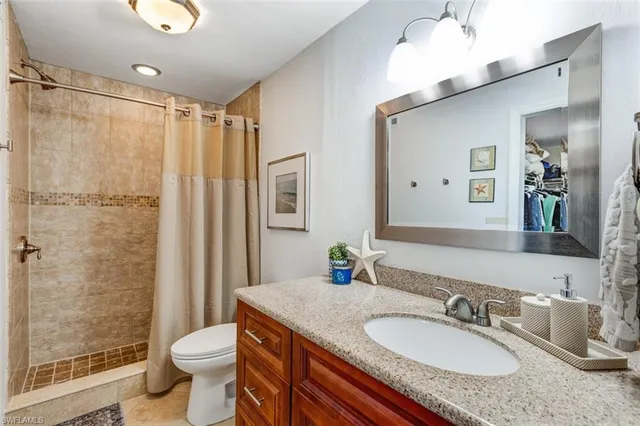 a bedroom with a large bed and a flat tv screen on dresser