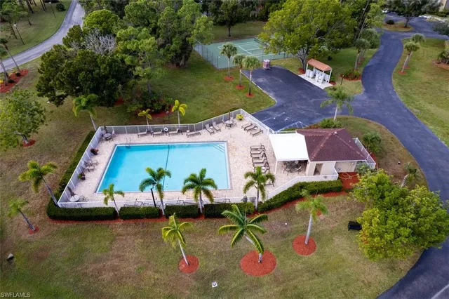 an aerial view of a swimming pool with outdoor seating and mountain view