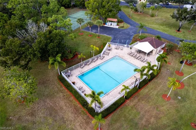 an aerial view of a swimming pool with outdoor seating