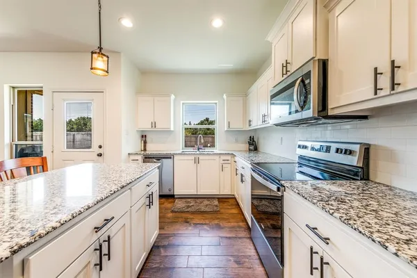 a kitchen with stainless steel appliances granite countertop a stove and a sink