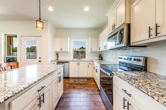 a kitchen with stainless steel appliances granite countertop a stove and a sink