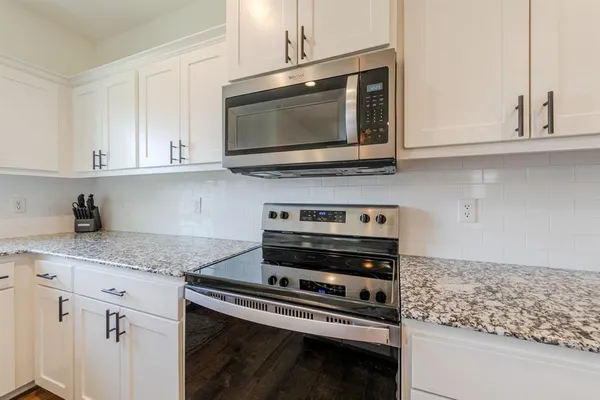 a kitchen with stainless steel appliances granite countertop a stove microwave and sink