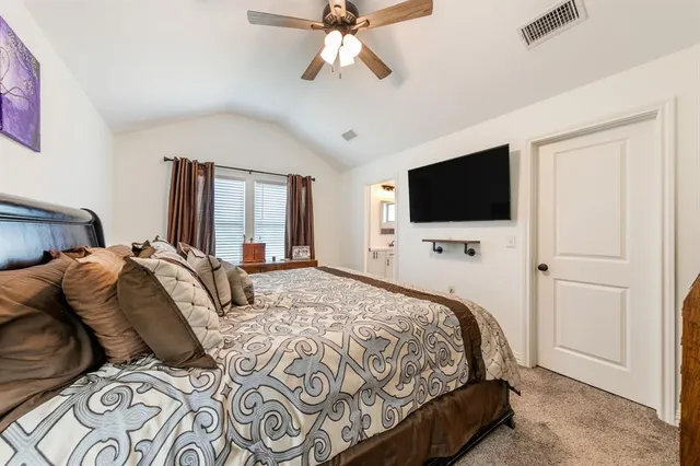 a bedroom with a large bed and a flat screen tv
