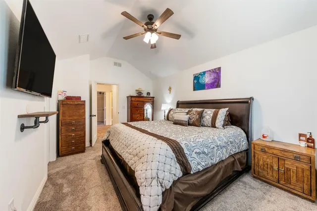 a bedroom with a large bed and a chandelier