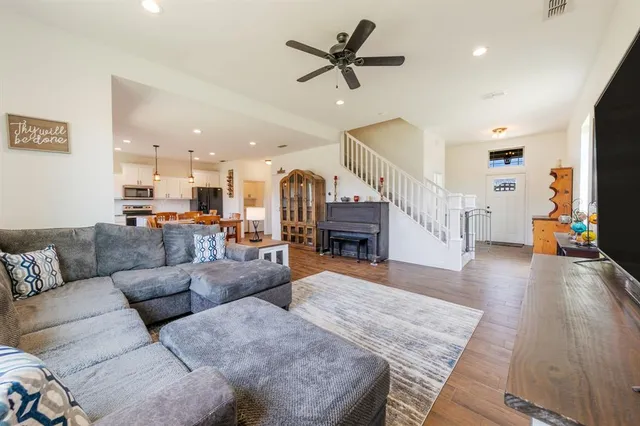 a living room with furniture and a wooden floor