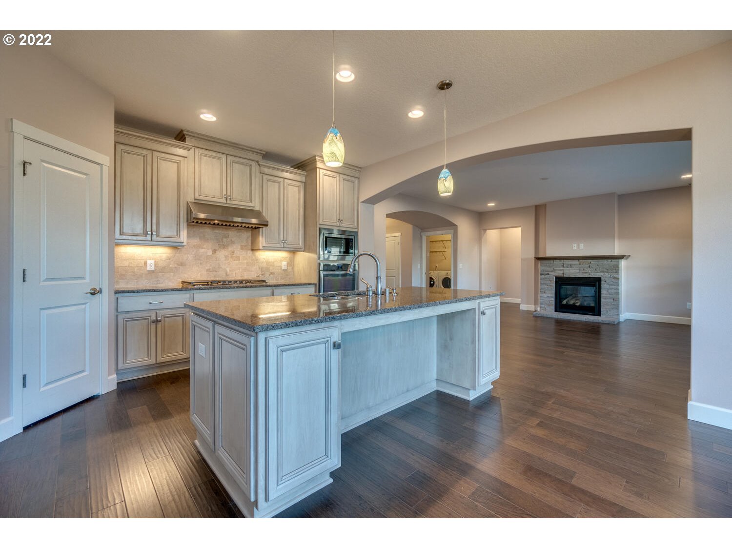 4724 North 6th Street Ridgefield, WA 98642 - Photo 8 of 32 a kitchen with kitchen island granite countertop a sink cabinets and wooden floor