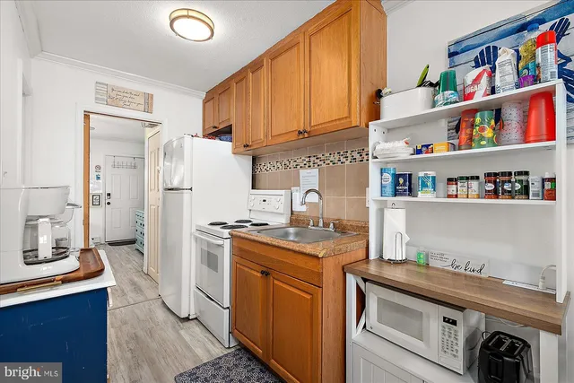 a kitchen with stainless steel appliances granite countertop a stove a sink dishwasher and refrigerator with wooden floor