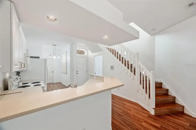 a view of a kitchen with wooden floor and a ceiling fan
