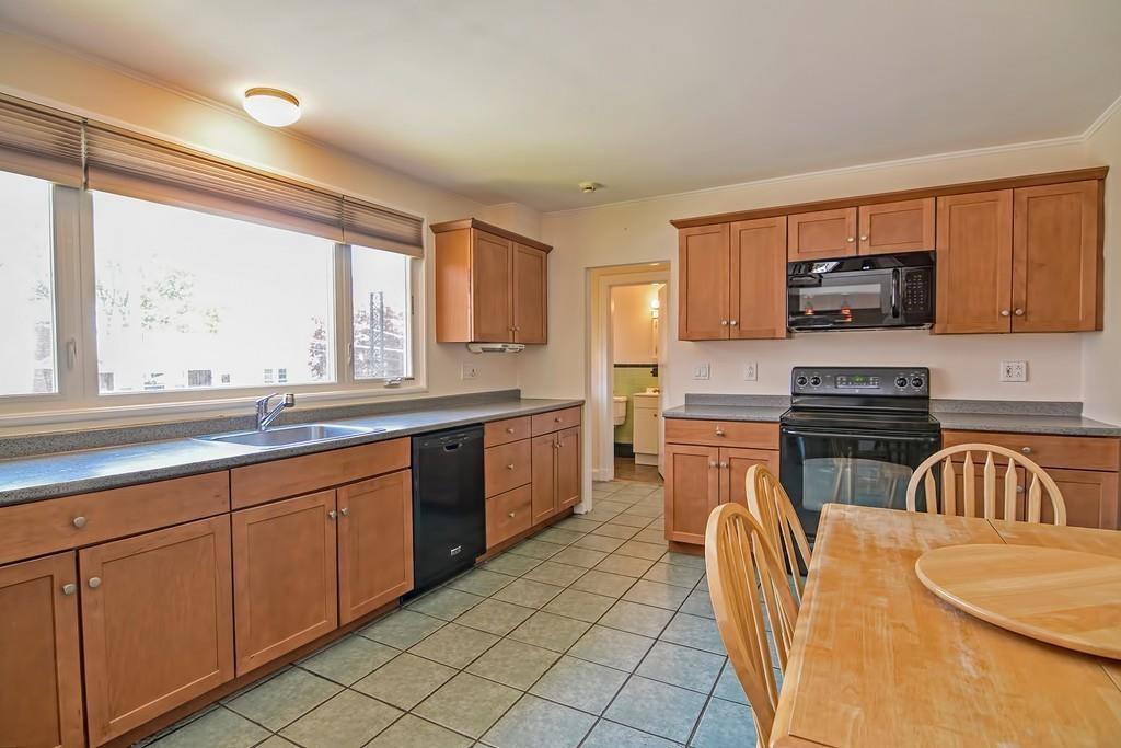 20 Westvale Road Medford, MA 02155 - Photo 16 of 42 a kitchen with stainless steel appliances granite countertop a sink a stove a microwave a counter top space and cabinets