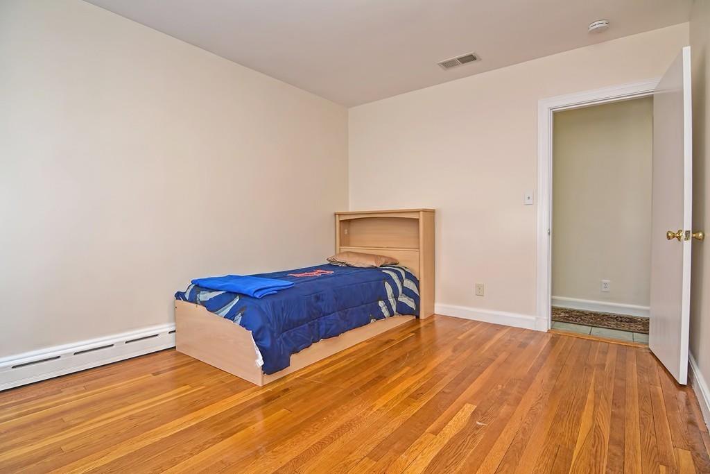 20 Westvale Road Medford, MA 02155 - Photo 22 of 42 a bedroom with a bed and wooden floor