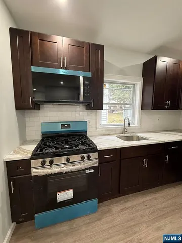 a kitchen with wooden cabinets and a stove top oven