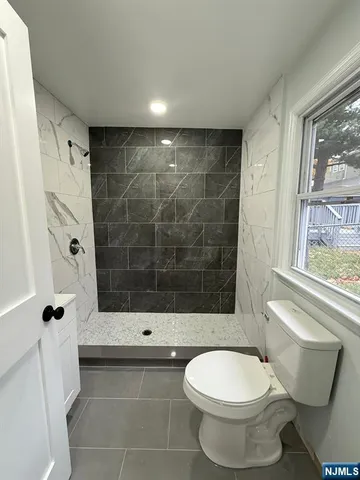 a bathroom with a toilet and a shower