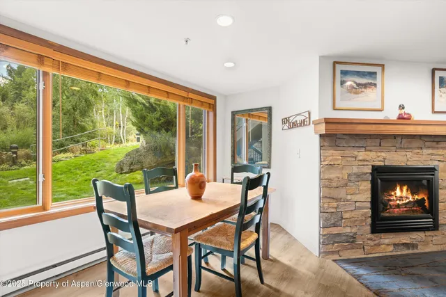 a dining room with furniture a fireplace and large windows