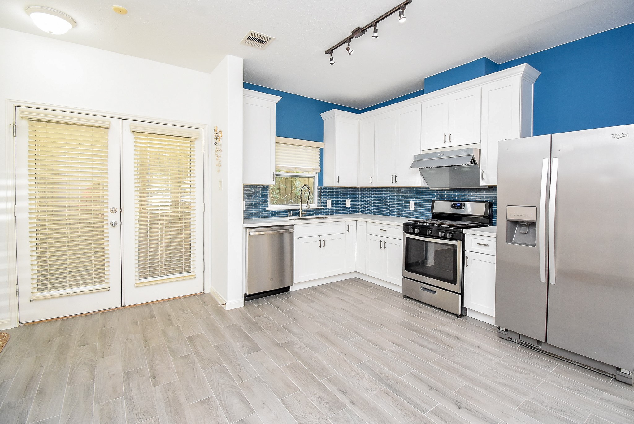 2202 Naomi Street, Unit 3 Houston, TX 77054 - Photo 10 of 42 a kitchen with granite countertop a refrigerator oven a sink dishwasher and white cabinets with wooden floor