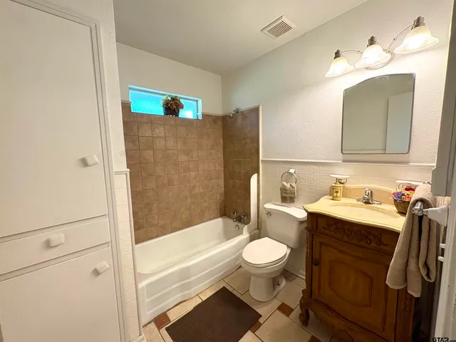 a view of a room with wooden floor chandelier fan and windows