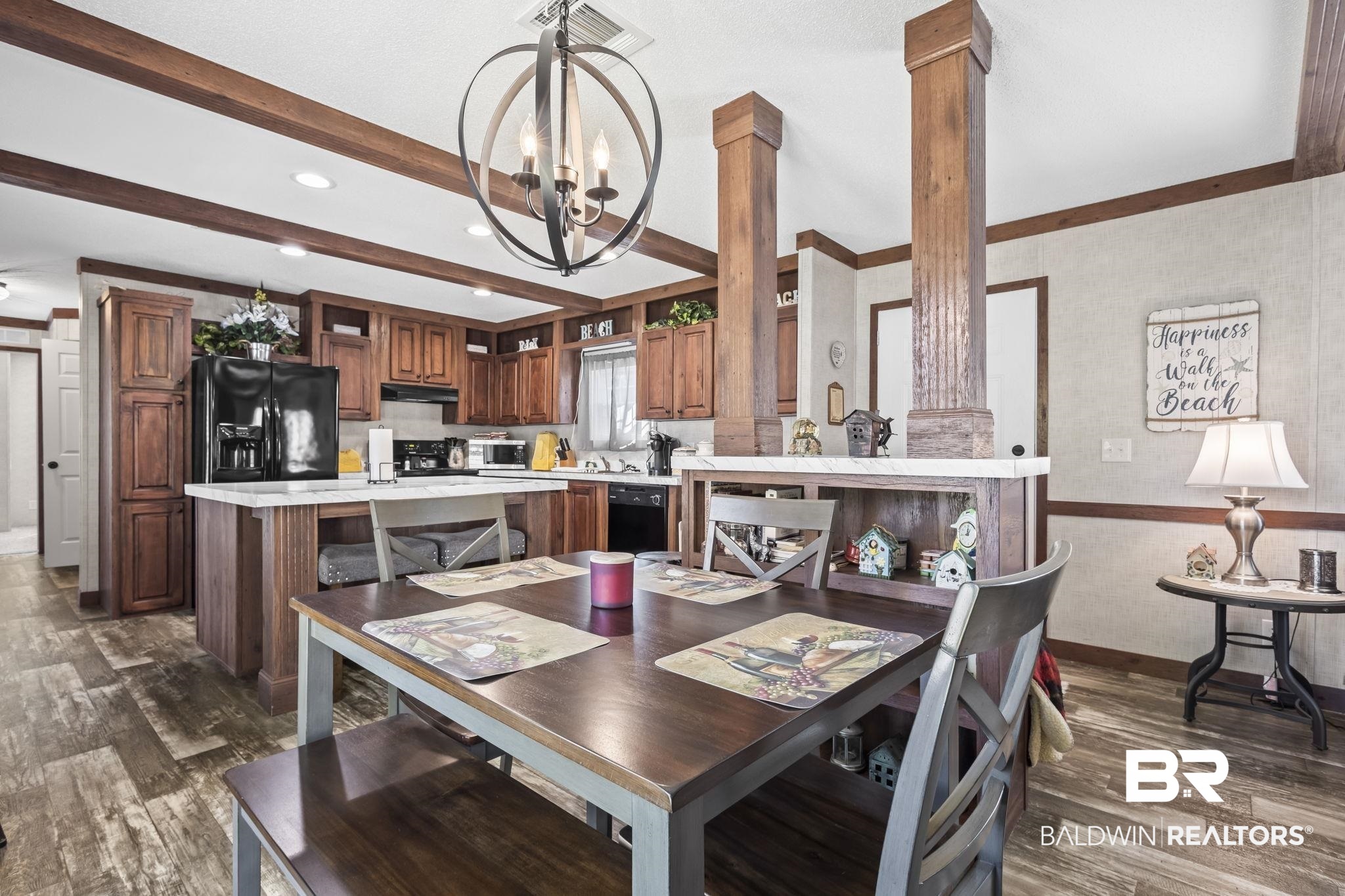 12960 7th Street Lillian, AL 36549 - Photo 21 of 25 Dining area featuring visible vents, a chandelier, beamed ceiling, decorative columns, and dark wood finished floors