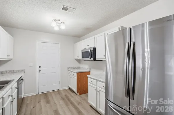 a kitchen with a refrigerator sink and cabinets