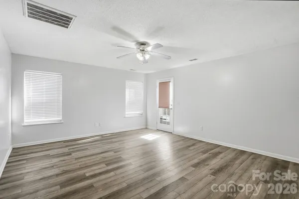 wooden floor in an empty room with a kitchen