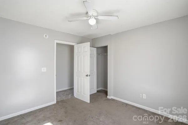 an empty room with a window and a fan