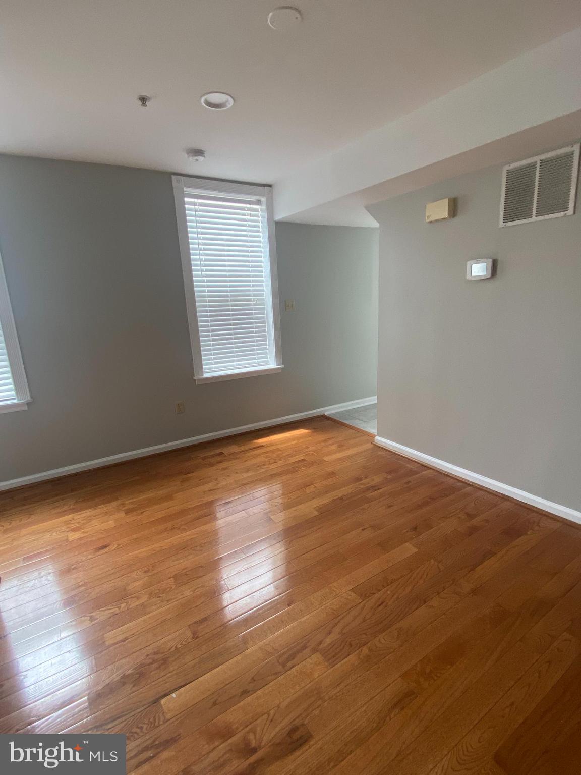 1458 Riverside Avenue, Unit 2C Baltimore, MD 21230 - Photo 11 of 14 a view of an empty room with wooden floor and a window