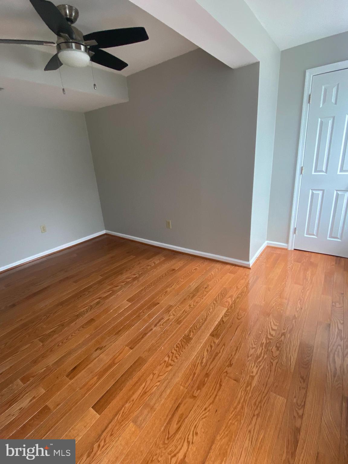 1458 Riverside Avenue, Unit 2C Baltimore, MD 21230 - Photo 12 of 14 an empty room with wooden floor fan and windows